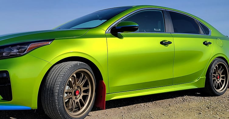Bright green vinyl-wrapped sports car parked outdoors after full color change wrap
