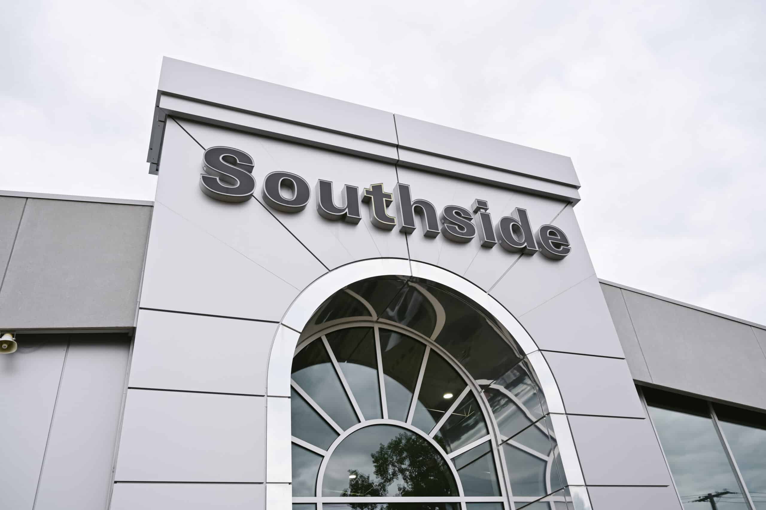 Modern building facade with "Southside" signage above an arched window, against a cloudy sky.
